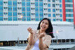 © M Alfan Setyawan - happy asian young woman hipster holding sparklers firework celebrate new year eve with dancing in roof top apartment with urban building background