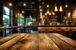 © Panuwat - Wooden table foreground restaurant cafe is made light-colored Set against a blur