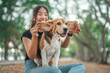 © oatawa - Happy asian woman playing with dog together in public park outdoors, Friendship between human and their pet