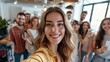 © Ruslan Gilmanshin - A woman enthusiastically takes a selfie in front of a lively group of people