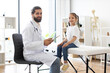 © sofiko14 - Portrait of Caucasian male doctor examining young girl in medical clinic. Doctor smiling while interacting with patient, symbolizing trust and care in healthcare setting.