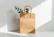 © Yulia - Eco-friendly paper bag with eucalyptus leaves in sunlit minimalist setting