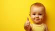 © Liliia - A baby is smiling and giving a thumbs up