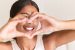 © puhhha - Dental Care. Woman Expressing Happiness And Self-Love With Heart-Shaped Hands. Bright Smile Reflects Confidence, Positive Energy, And Personal Connection.