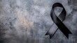 © Kultivad - Black awareness ribbon on textured gray surface symbolizing mourning with generous blank space for text or messages.