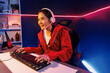 © Summit Art Creations - Host channel of smiling beautiful Asian girl streamer playing online game wearing headphone talking with viewers media online recording phone. Esport skilled team players in neon blue room. Stratagem.