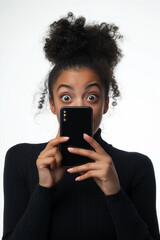 Wall Mural - Young woman showing a smartphone screen, smiling and winking at the camera, isolated on a white background.