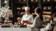 © alexandra_pp - A smiling chocolatier in a white uniform hands a red gift box to a customer, with a counter displaying assorted chocolates and floral decor in an elegant, upscale shop setting.