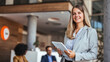 © Dragana Gordic - Confident Business Woman Holding Tablet in Modern Office Setting