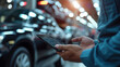 © FNB business illust - Auto technician using digital tablet to diagnose car problems in factory