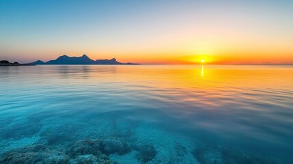 Wall Mural - Picturesque view of a clear sea at sunrise, golden light on the water, and space for copy.