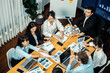 © InfiniteFlow - Wide top view of diverse group of business analyst team analyzing financial data report paper on meeting table. Chart and graph dashboard by business intelligence analysis. Meticulous