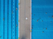 © AmazingAerialAgency - Aerial view of public pools with people swimming on a sunny summer day, Wedding, Germany.