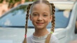 © Yuliia - Adorable happy smiling Caucasian little girl child kid daughter portrait schoolgirl looking at camera friendly wide cheerful smile posing car outside city street. Travelling adoption transportation