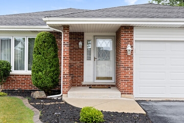 Wall Mural - A front door detail on a red brick home with white windows, covered porch, and white doors.