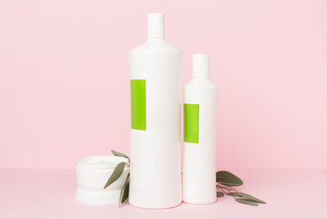 Wall Mural - Shampoo and hair mask with green leaves on color background