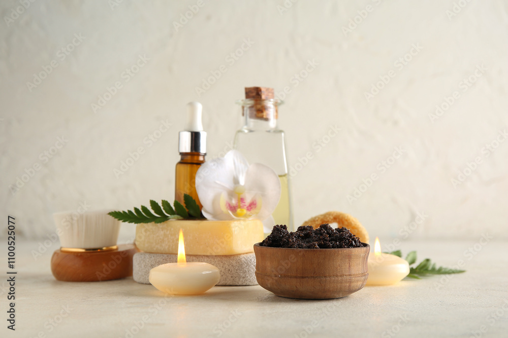 Composition with coffee body scrub, candles and flower on light grunge background