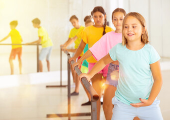 Wall Mural - Children exercising ballet moves during their group training.