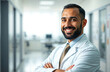 © Artem Zatsepilin - healthcare, medical research, patient care, medicine. Middle Eastern male doctor in white lab coat with arms crossed standing in hospital, smiling at camera.