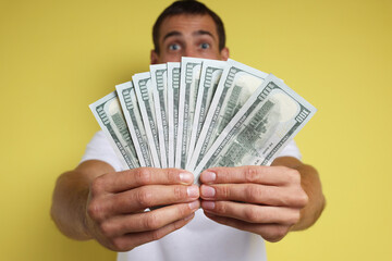 Wall Mural - Man with dollar banknotes on yellow background, selective focus