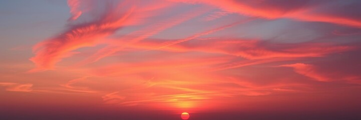 Wall Mural - vibrant hues of orange and pink streak across the sky as the sun sets, casting a warm glow over the 