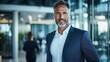 © Gefo - Confident businessman standing in a modern office environment