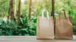 © Pornphan - Eco friendly paper bags on wooden table in lush green forest