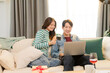 © Rakchanok - Shopping, holiday season, Christmas celebrations, young newlywed couples spend time together in Xmas festive shopping online by using credit card to order ornaments to decorate domestic room for party