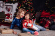 © dmitriisimakov - girl and mom in bedroom by Christmas tree with gifts for new year