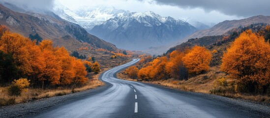 Wall Mural - Scenic serpentine road through colorful autumn mountains under dramatic cloudy sky