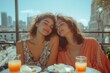 © GHM_STUDIO - Cheerful women sharing a relaxed outdoor breakfast with orange juice