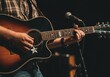 © SERHII - Young man playing acoustic guitar on stage under spotlight