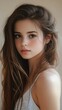 © BrandwayArt - Young woman with long hair poses softly against a neutral background