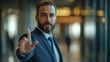 © Lion - A businessman holding his hand up in a professional stop gesture, formal suit, modern office blurred background, neutral facial expression, sharp focus on the hand,