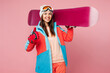 © ViDi Studio - Snowboarder young woman wears warm blue padded jacket ski goggles mask spend extreme weekend winter season in mountains hold snowboard show thumb up isolated on plain pink background. Hobby concept.