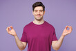© ViDi Studio - Young Caucasian man wear violet t-shirt casual clothes hold spreading hands in yoga om aum gesture relax meditate try to calm down isolated on plain pastel light purple background. Lifestyle concept.