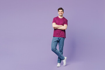 Full body young smiling happy Caucasian man wear violet t-shirt casual clothes hold hands crossed folded look camera isolated on plain pastel light purple background studio portrait Lifestyle concept