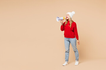 Canvas Print - Full body merry young woman in red sweater hat hold in hand megaphone scream announces discounts sale Hurry up isolated on plain beige background Happy New Year celebration Christmas holiday concept