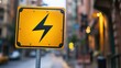 © Youttakone - A bright yellow warning sign with a lightning bolt symbol, indicating high voltage or electrical hazards in an urban environment.