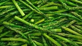 Close-up shot of fresh raw green asparagus displaying vivid color and crisp texture, highlighting individual spears arranged densely.