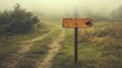 © ratcha - A foggy landscape with a wooden signpost directing to the right on a dirt path.