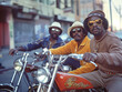 © Rohit k  - Three stylish bikers sporting sunglasses and hats strike a pose on their custom chopper motorcycles, radiating a hip and defiant vibe in a vintage city setting reminiscent of the 1970s