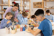 © JackF - Interested children of different ages painting ceramic objects with teacher in art studio
