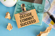 © Pawel - Conceptual hand writing showing Decide Commit Succeed. Business photo text achieving goal comes in three steps Reach your dreams Register pages handwriting text work stationery items woody table.