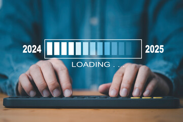 Wall Mural - businessman typing on computer keyboard with loading icon change from 2024 to 2025 for preparation m