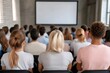 © olegganko - Group of men attentively watching a presentation in a modern conference space during the day