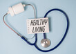 © Pawel - Healthy Living text on blue blackboard with stethoscope