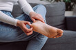 © Yura Yarema - Close up of young woman scratching itch on her feet. Cause of itchy skin include athlete's foot, fungal infection, dermatitis and eczema, psoriasis, or bug bites. Health care concept