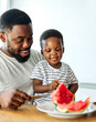 © Lumos sp - child family kitchen food boy son father watermelon fruit slice summer organic meal fun preparing healthy diet eating home black