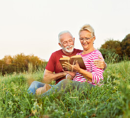 Wall Mural - woman man outdoor senior couple happy lifestyle retirement together smiling love reading nature book